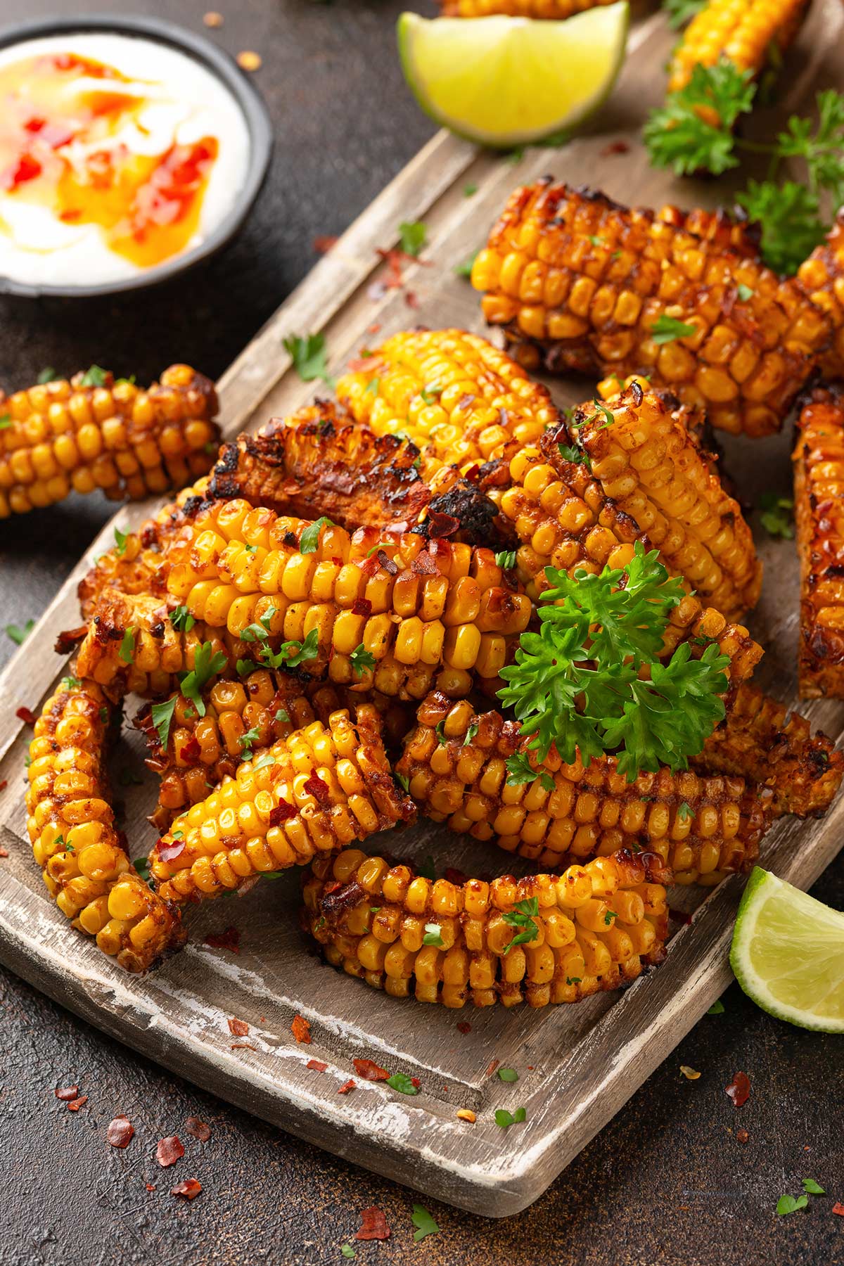 corn ribs on a wooden board garnished with parsley and lime wedges