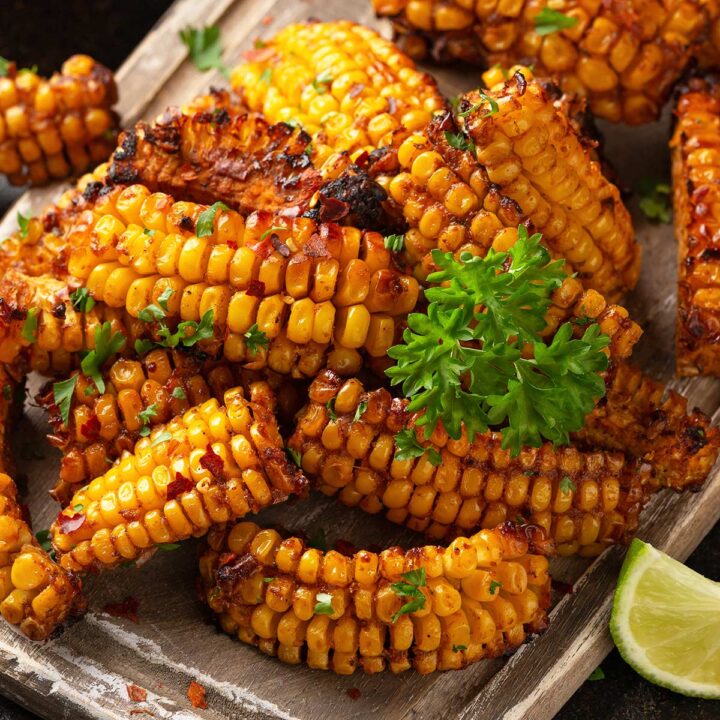 close up of a board of corn ribs with butter, lime and red pepper flakes
