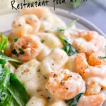 Pinterest image: Creamy shrimp gnocchi on a grey plate with text overlaid