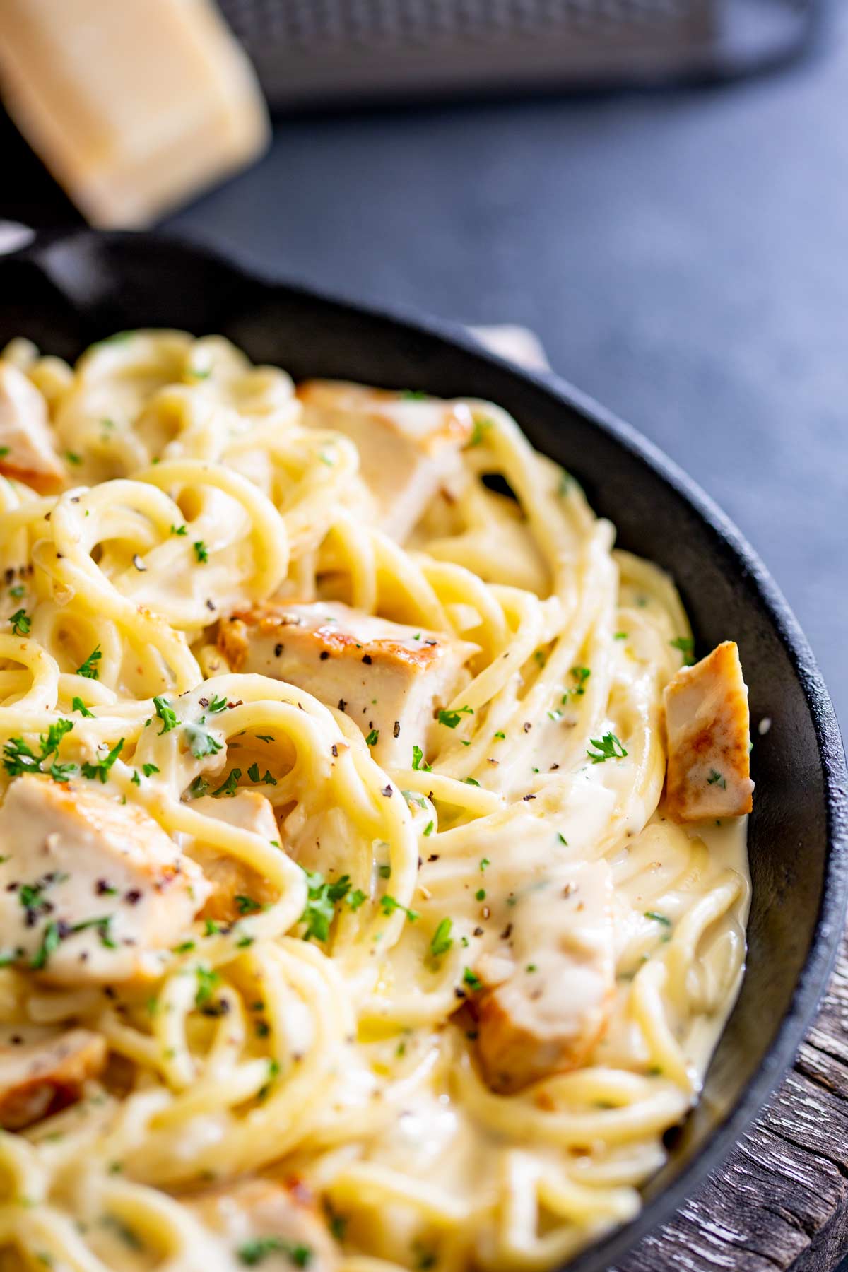 chunks of chicken with creamy spaghetti in a cast iron skillet