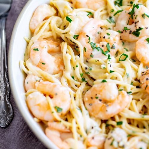 overhead of shrimps nestled in a bowl of creamy pasta