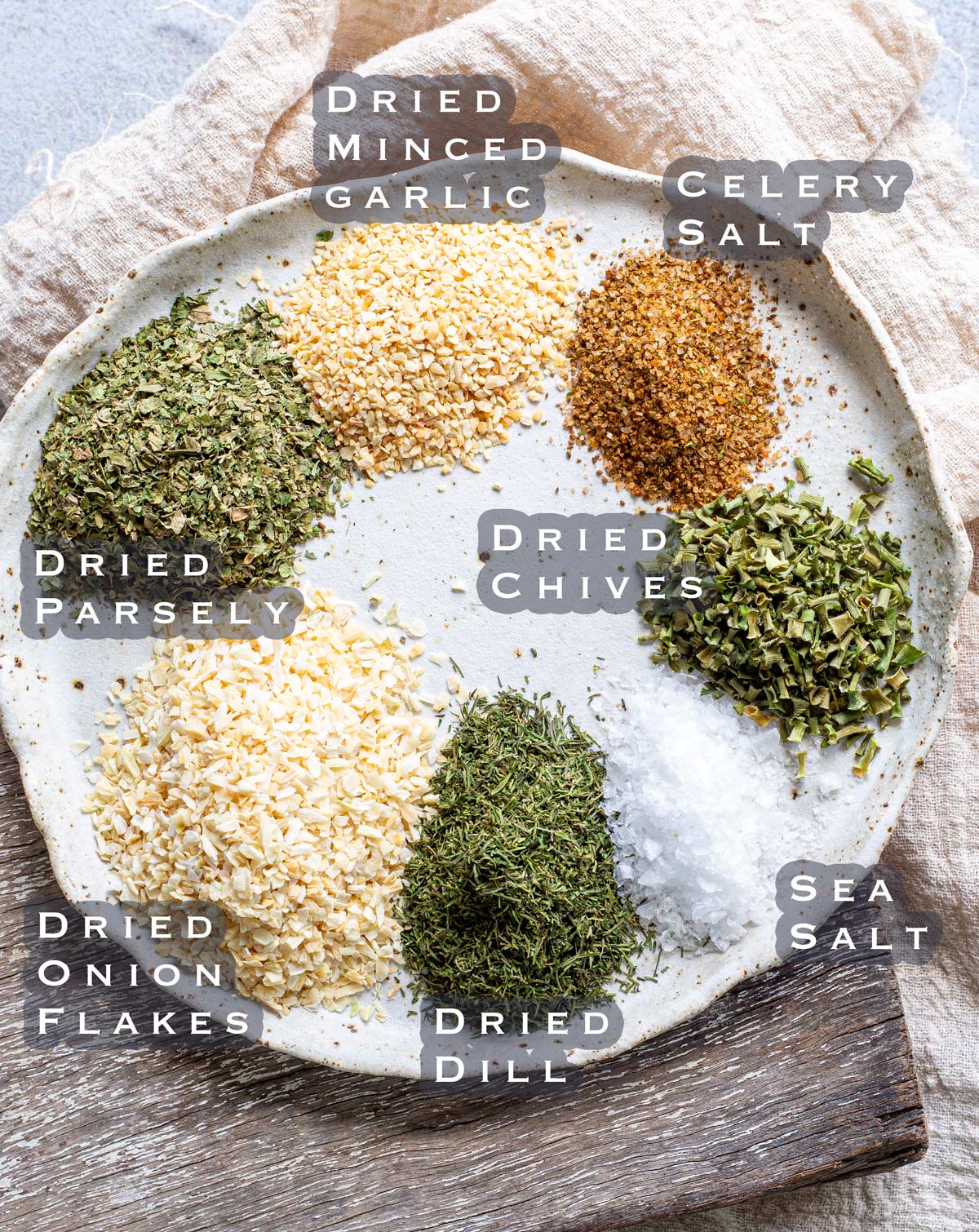 a plate with piles of herbs on it showing the ingredients for dill seasoning blend