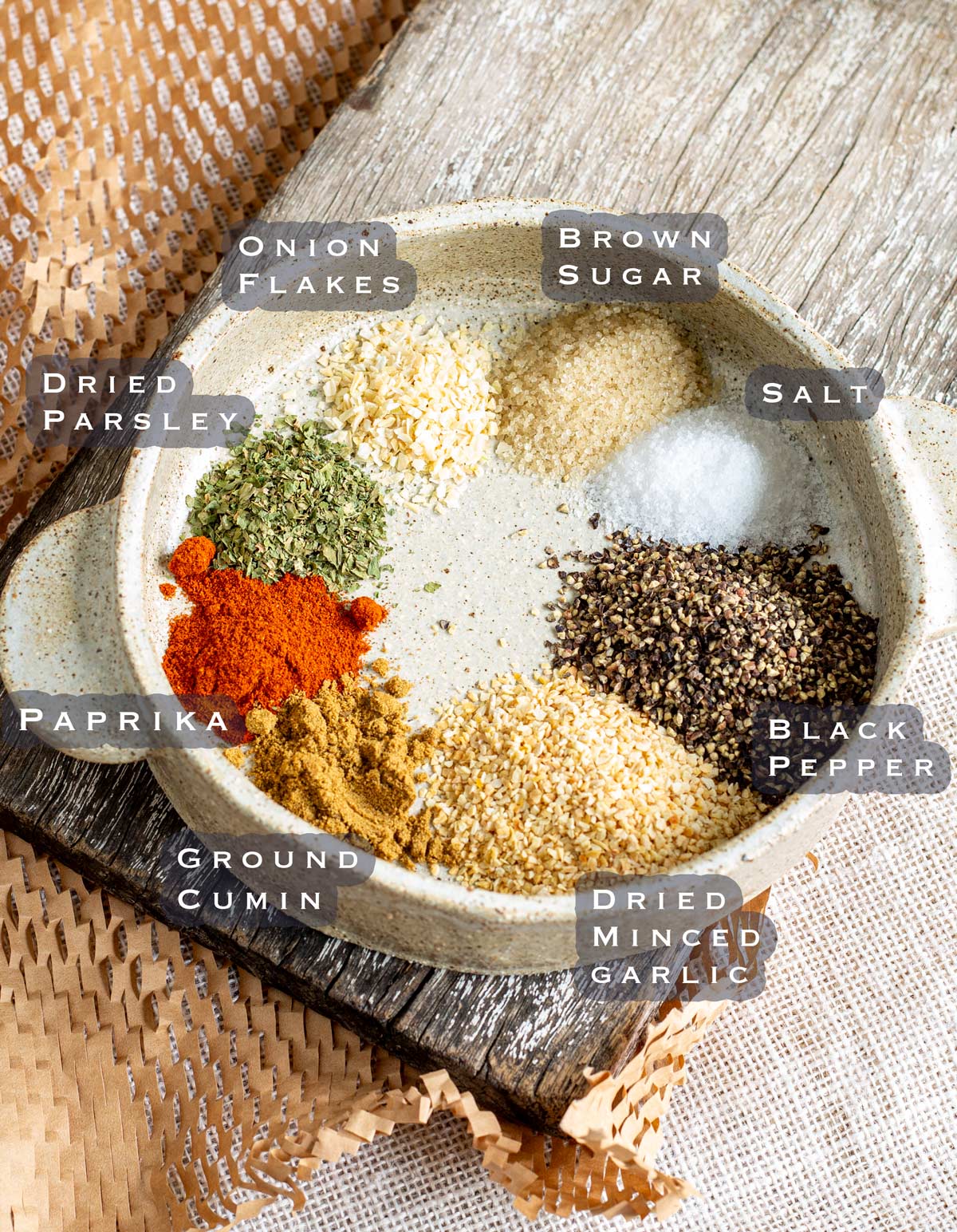 ingredients for homemade garlic pepper seasoning in a rustic bowl