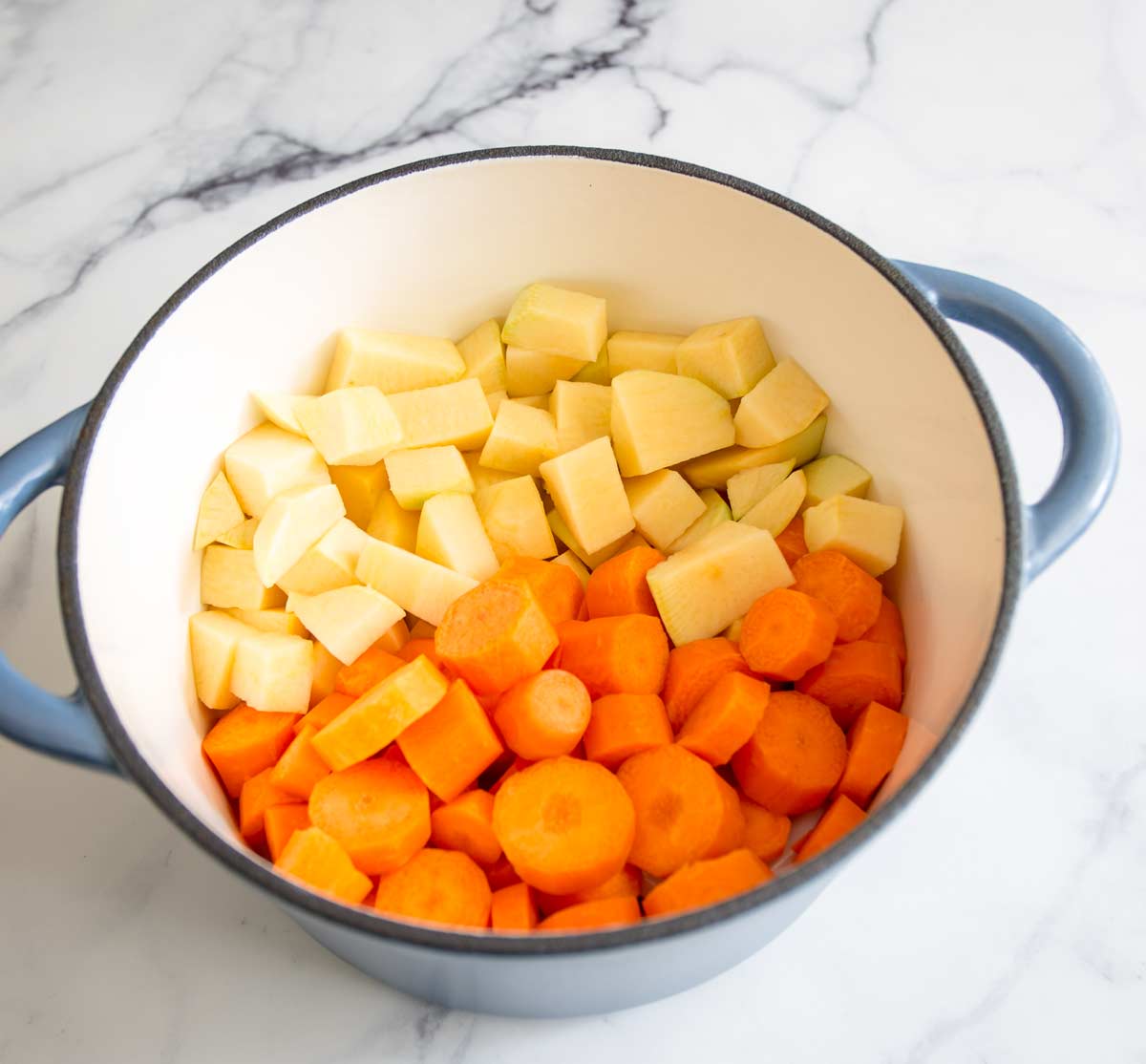 chopped rutabaga and carrot in a cast iron dutch oven
