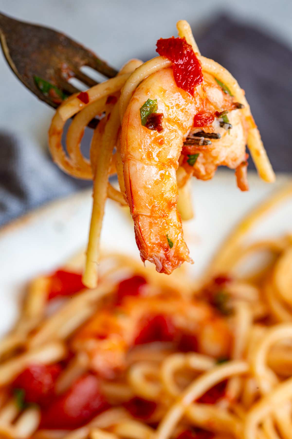close up of a fork with a spicy shrimp on it