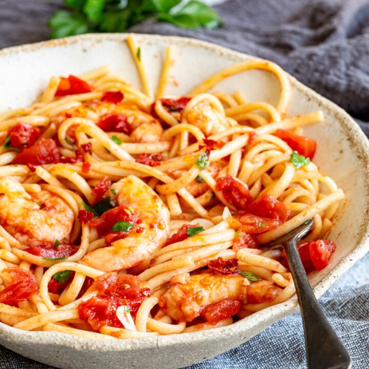 close up on the shrimp in a bowl of spaghetti with a. spicy tomato sauce