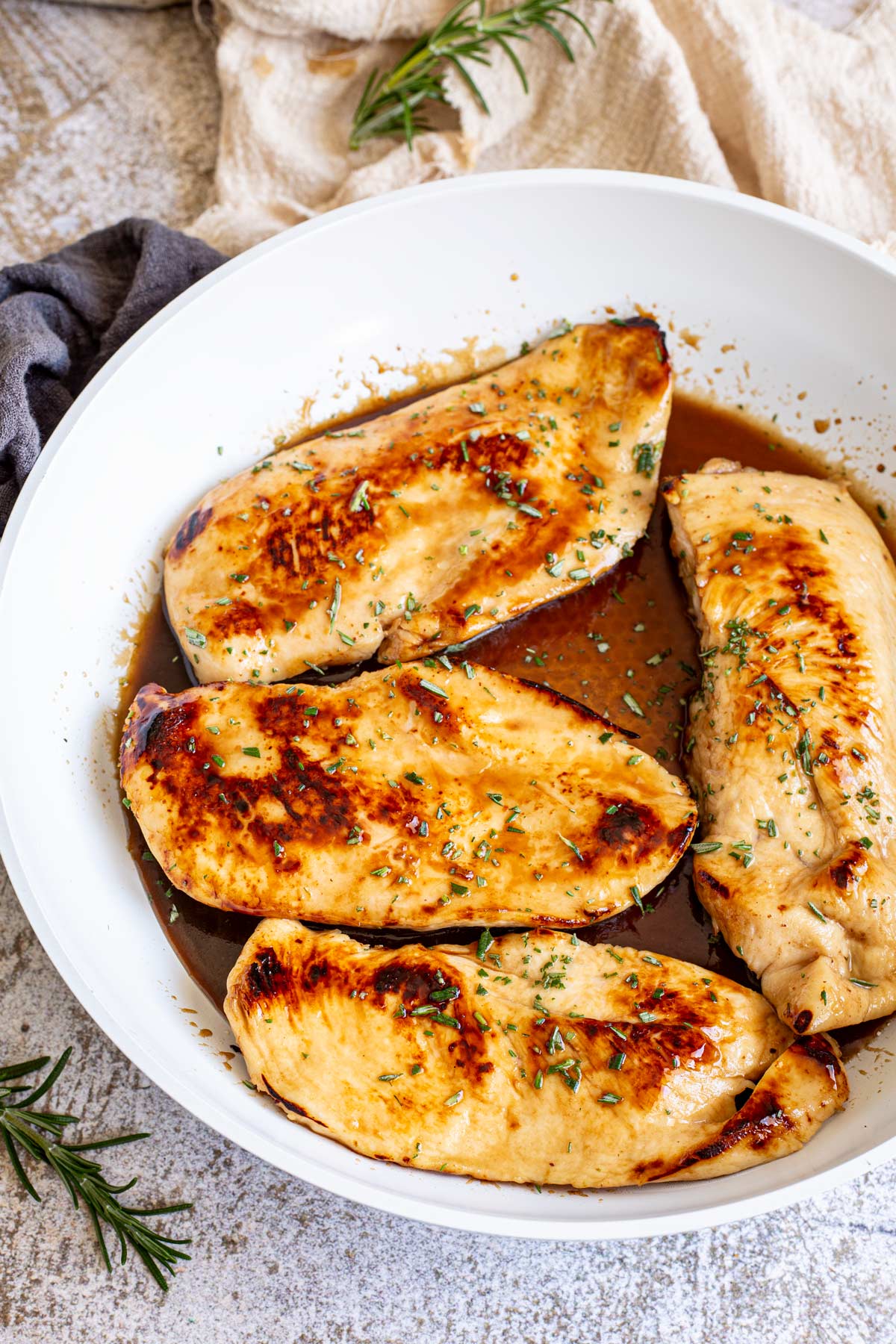 a white skillet with 4 chicken breasts in a balsamic sauce