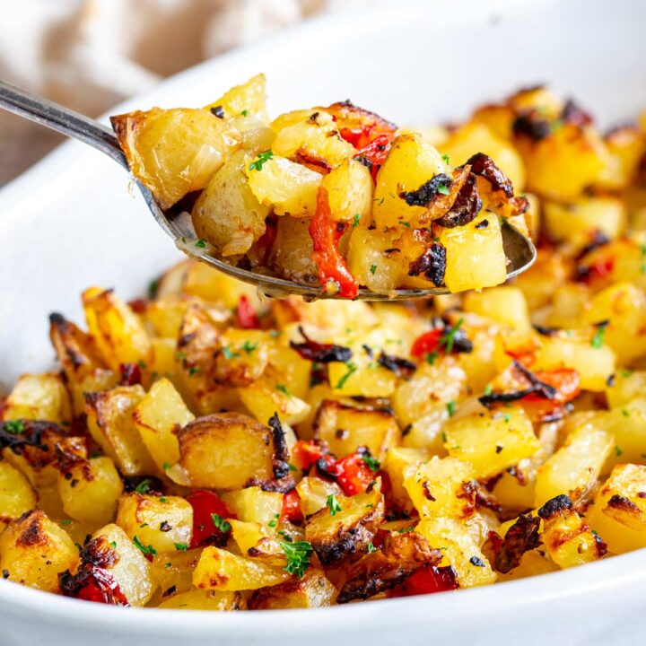 close up on a spoon scooping up some cubes of crispy potatoes