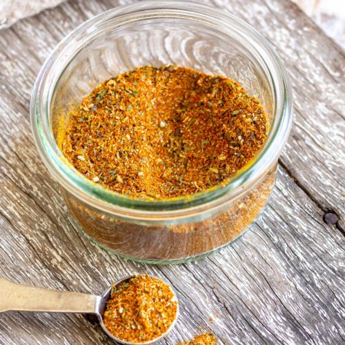 a close up on a small glass ramekin of orange spices