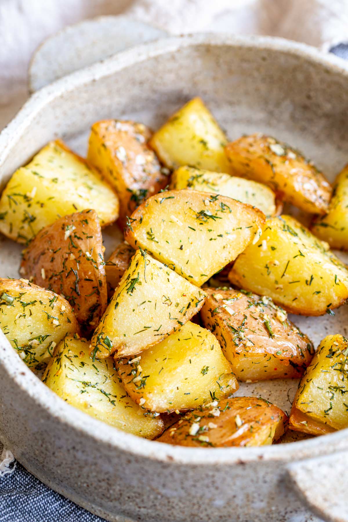 close up on dill potatoes in a rustic round dish