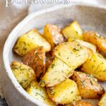 pin image: Dill potatoes in a rustic stoneware dish with text overlaid