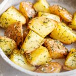 pin image: Dill potatoes in a rustic stoneware dish with text overlaid