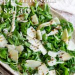pin image: An arugula salad on a rustic plate with text overlaid