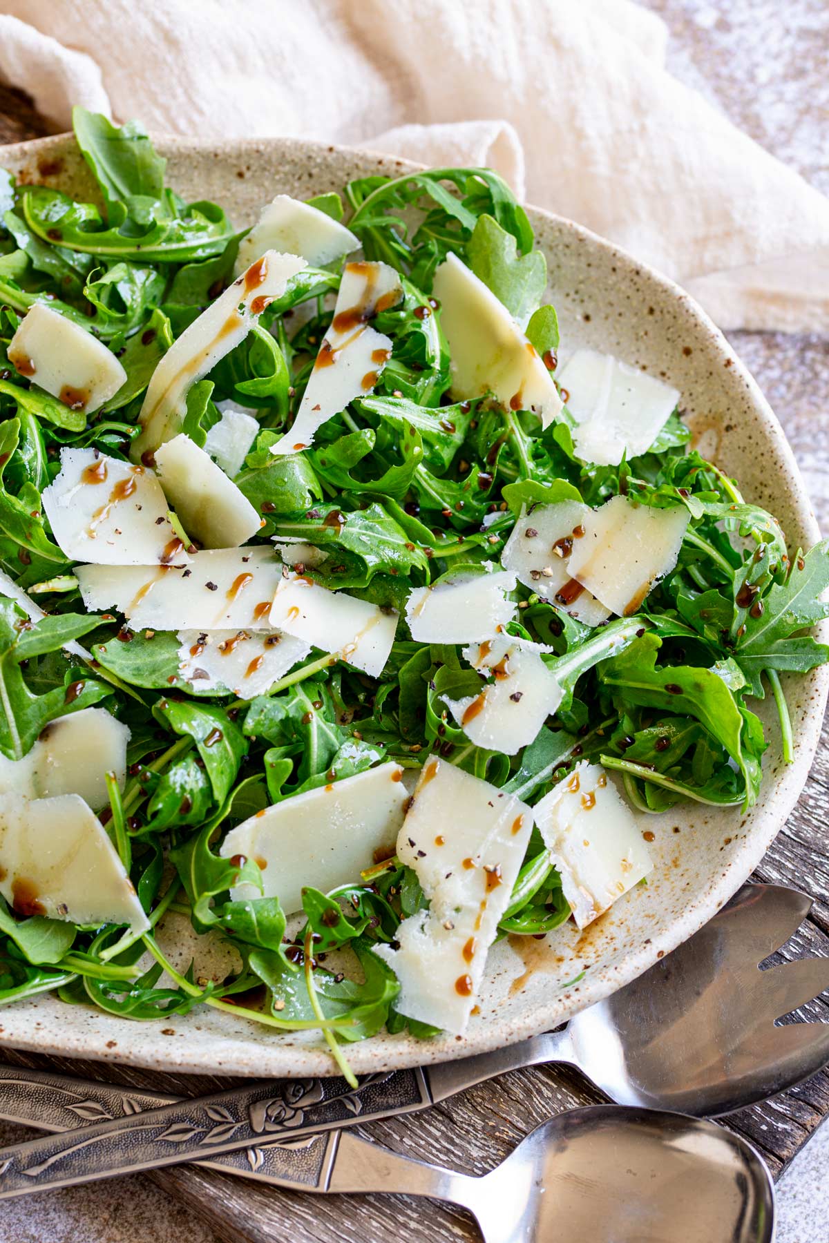 a rustic plate of arugula salad on a wooden board