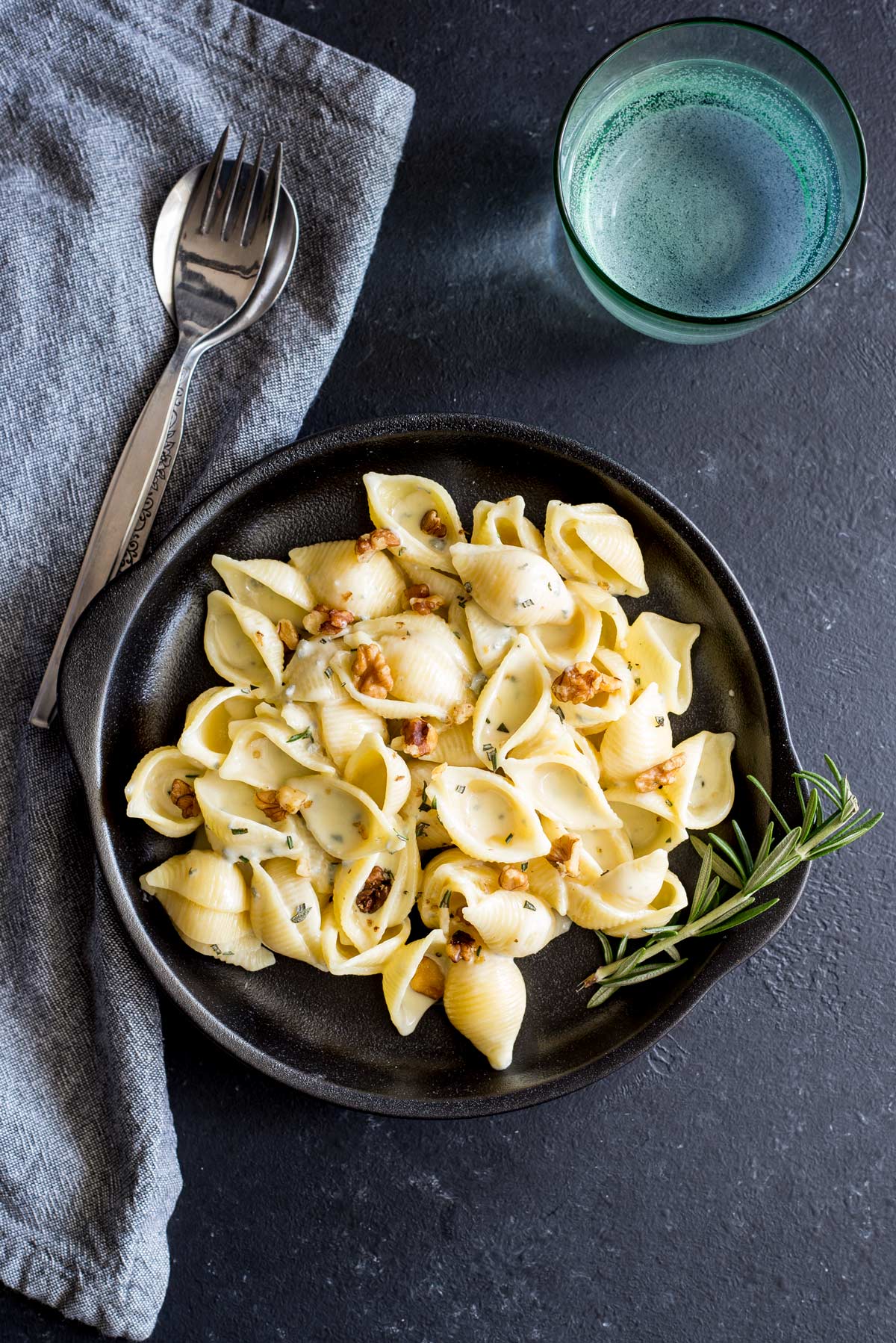 overhead view of a back plate with pasta shells in a creamy blue cheese sauce