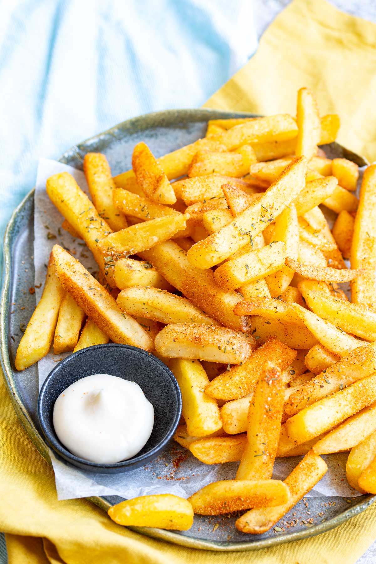 a blue and yellow napkin with a plate of cajun fries on top of it