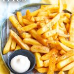 Pin Image: Cajun Fries on a plate with mayonnaise. Text overlaid