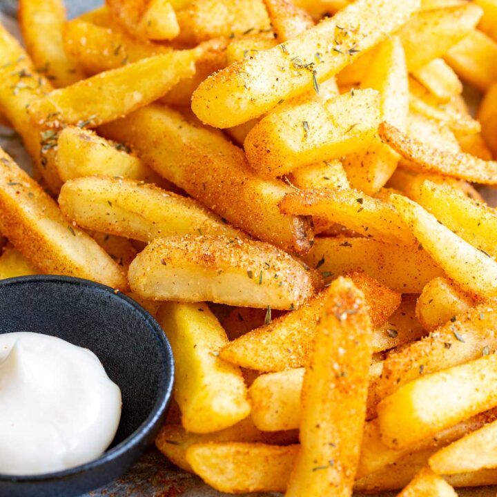 super close up on some French fries coasted in an orange seasoning