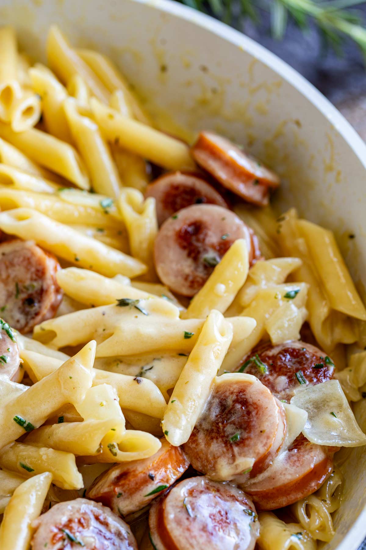 close up on the pasta in a skillet showing how the sauce is clinging to it