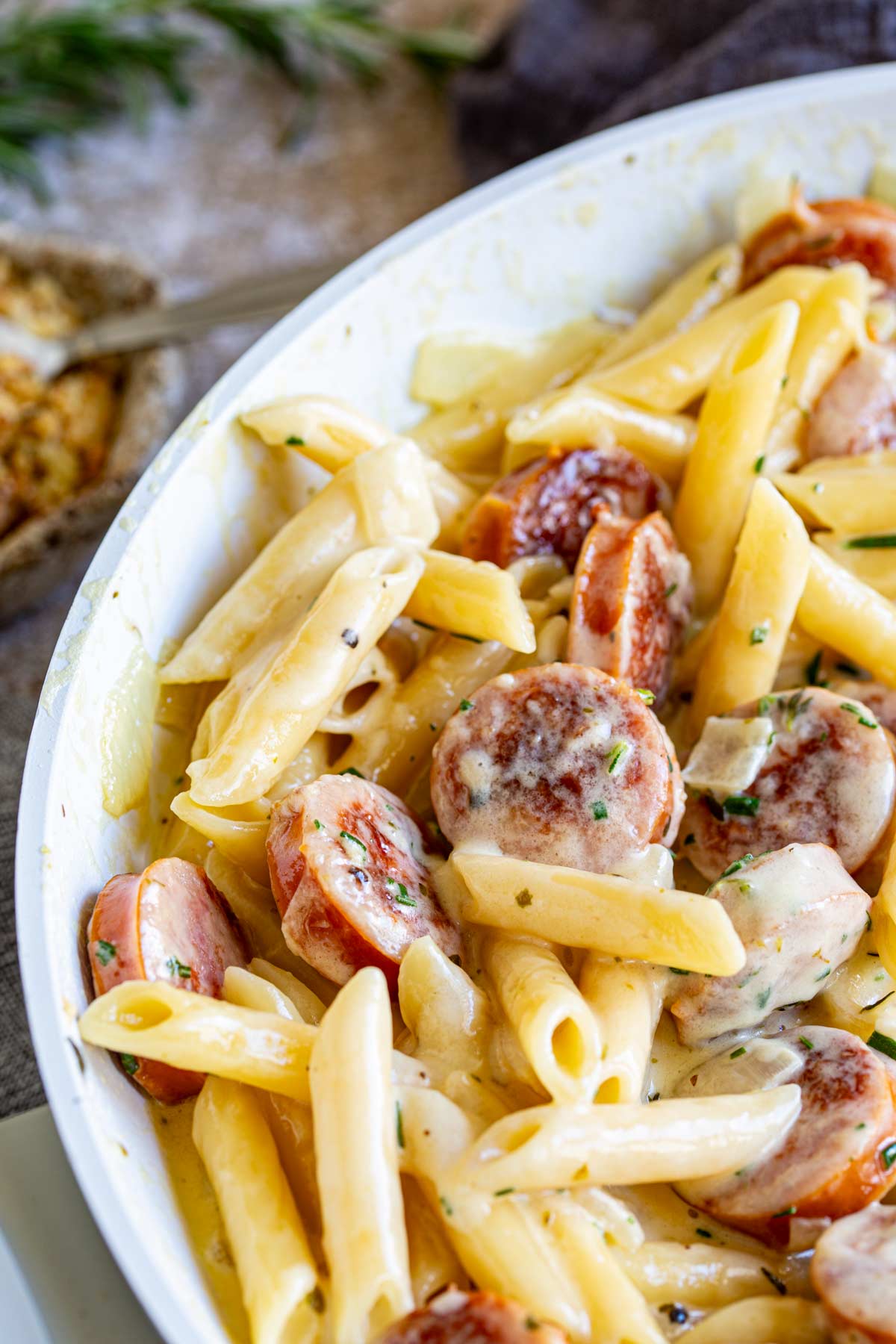 smoked sausage and penne in a cream sauce in a white pan