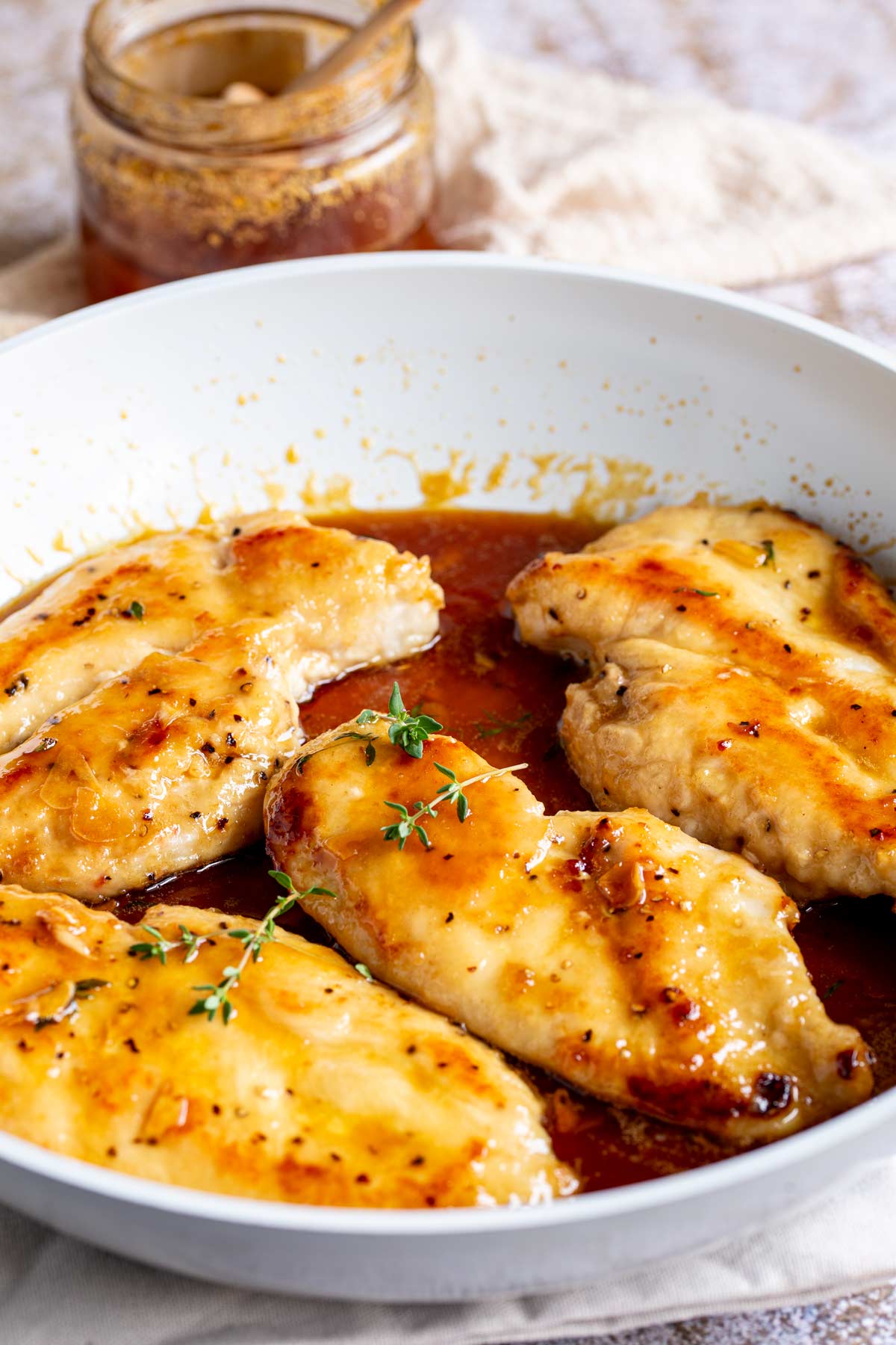 4 glazed chicken fillets in a white skillet