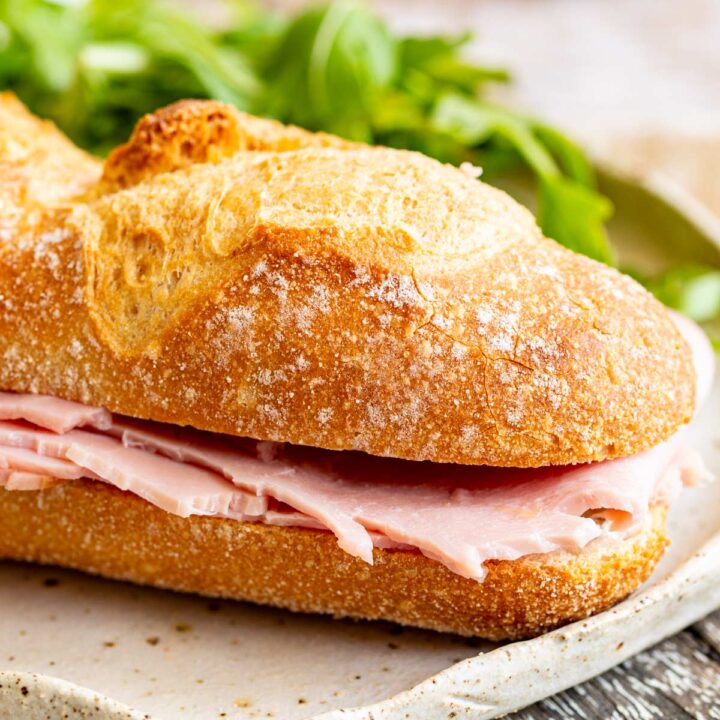 close up on a crusty baguette filled with French ham