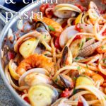 pin image: shrimp and clam pasta in a pan with text overlaid