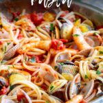 pin image: shrimp and clam pasta in a pan with text overlaid