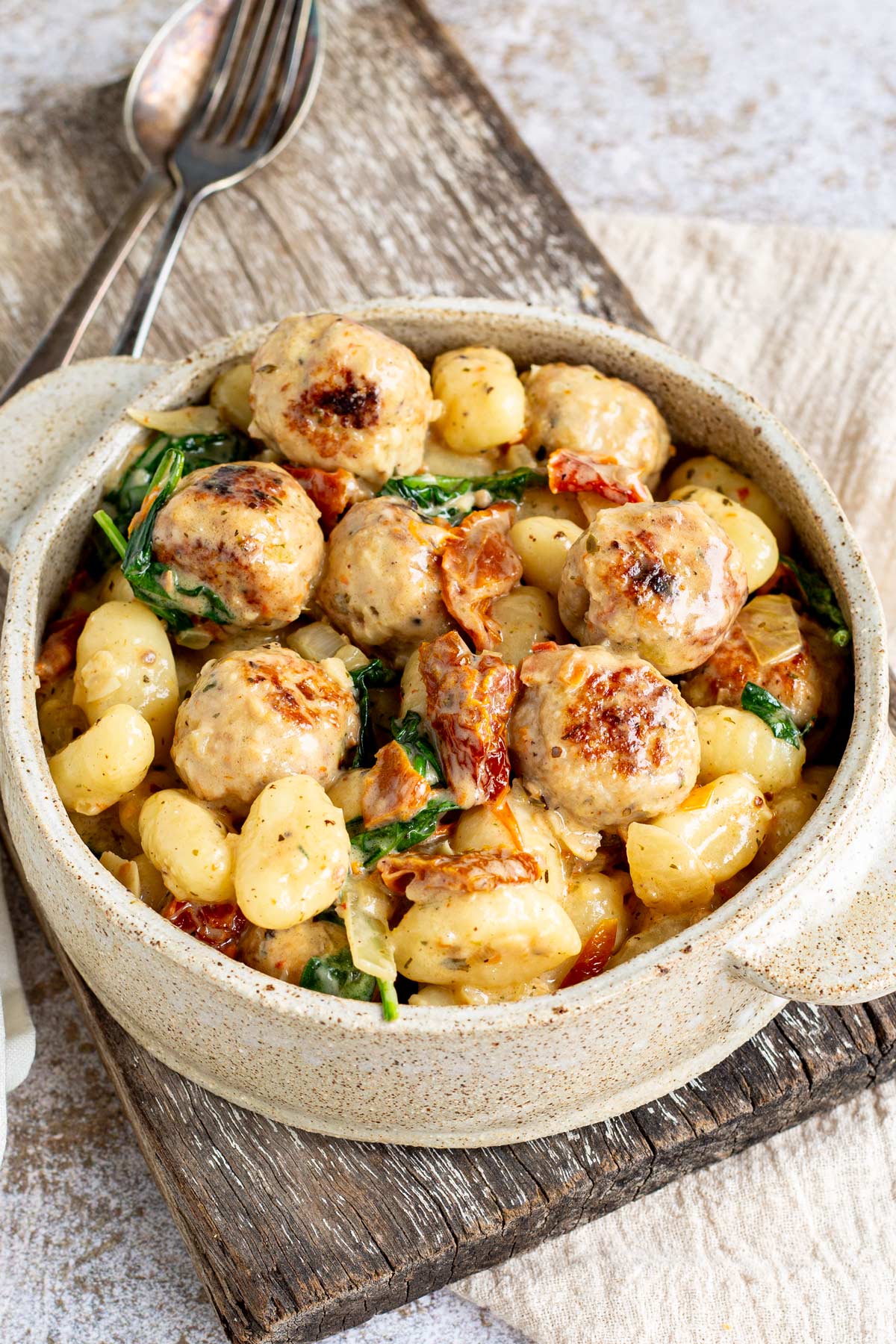 overhead shot of tuscan meatballs and gnocchi in a rustic bowl with handles