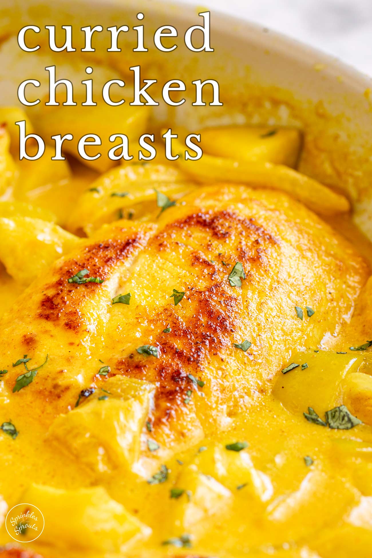 pin image: Curried chicken beasts in a skillet with text overlaid