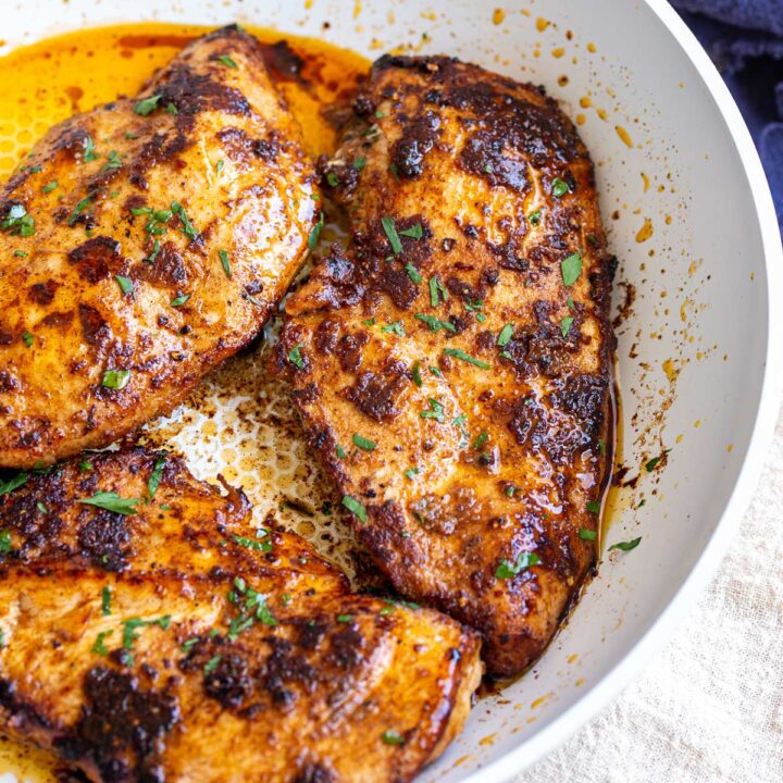 close up on a cooked chicken breasts coated in a rich spice mix