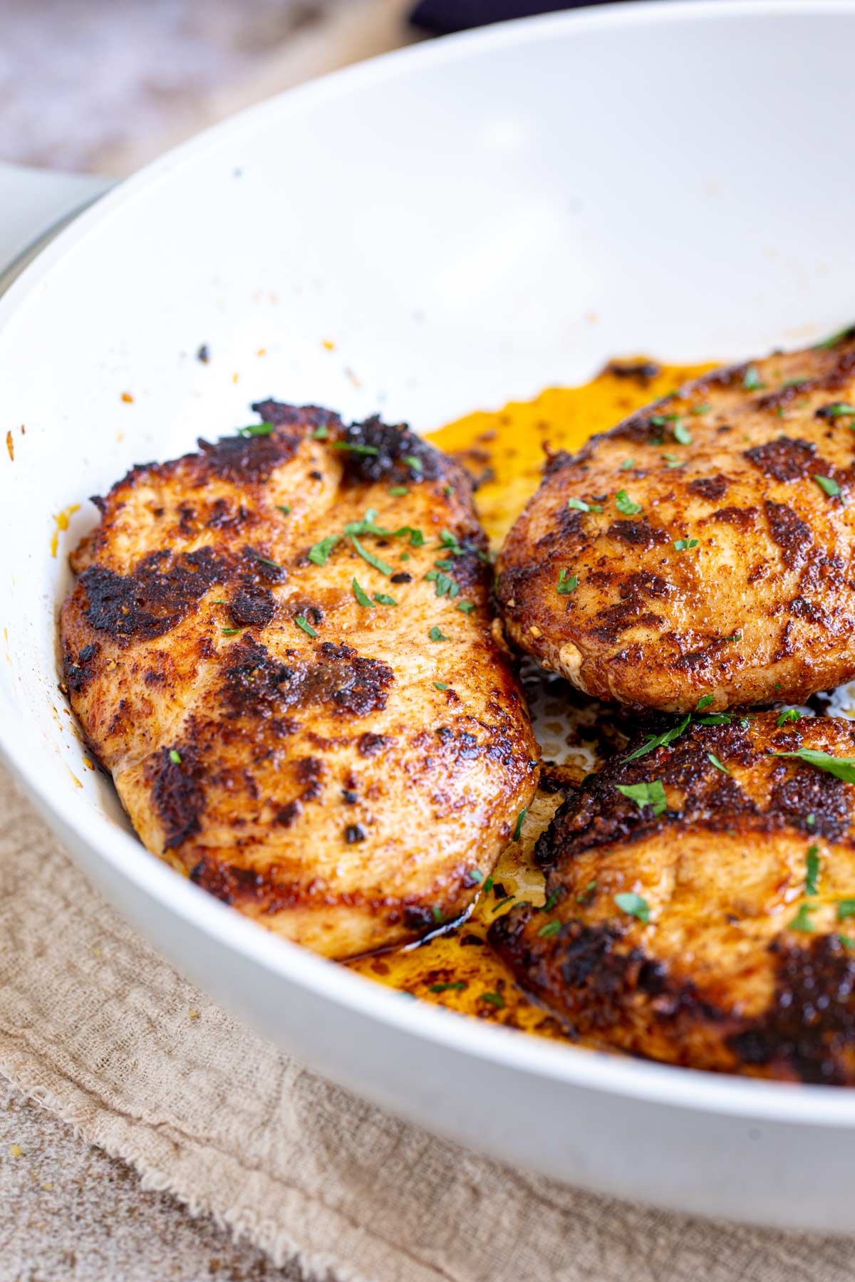 close up on aMoroccan Chicken Breasts in a white skillet