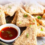 pin image: sesame chicken toasts on a pate with text overlaid