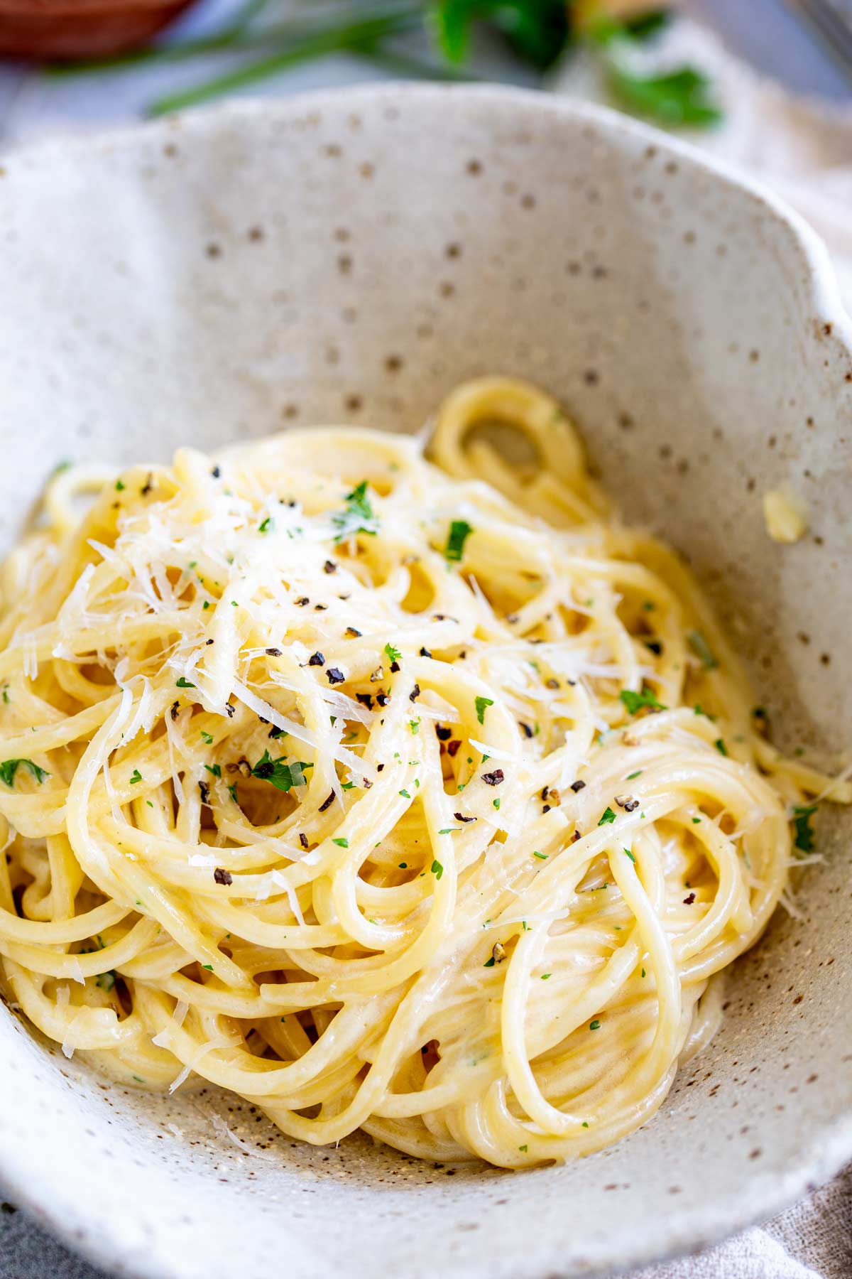 creamy cheesy spaghetti in a rustic bowl