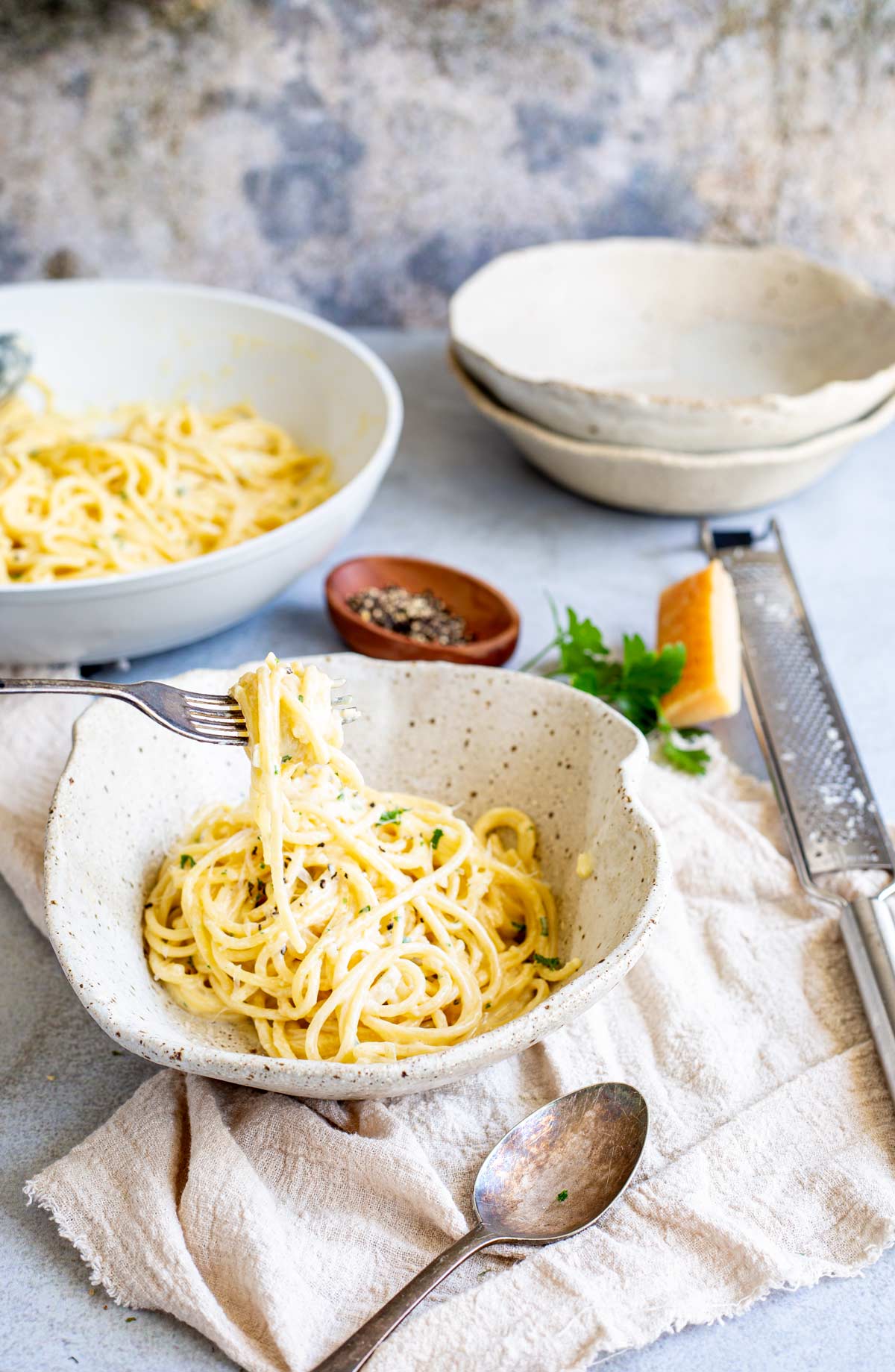 rustic bowls on a table, one filled with creamy pasta