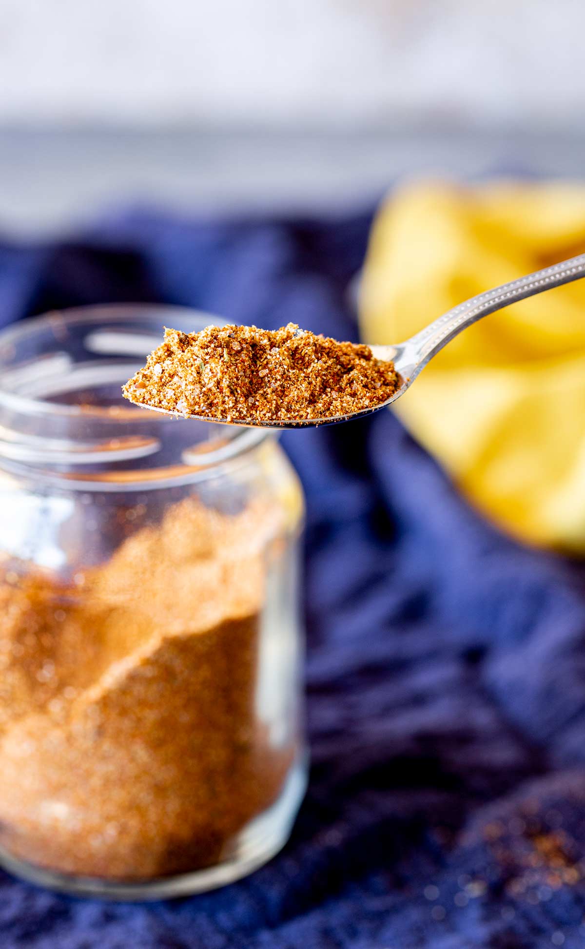 a spoon lifting seasoning from a glass jar