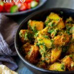 pin image: Saag aloo in a black bowl with text overlaid