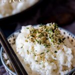pin image: a small bowl of sticky rice sprinkled with furikake with text overlaid