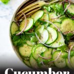 Pin Image: A bowl of asian cucumber salad with red onions with text overlaid