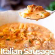 Pin Image: Close-up of creamy sausage soup with pasta on a spoon with text overlaid
