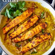 Pin Image: Salmon daal in a white cast iron skillet with text overlaid