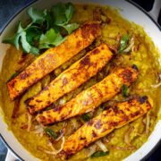 Pin Image: Salmon daal in a white cast iron skillet with text overlaid