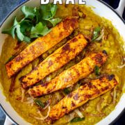 Pin Image: Salmon daal in a white cast iron skillet with text overlaid