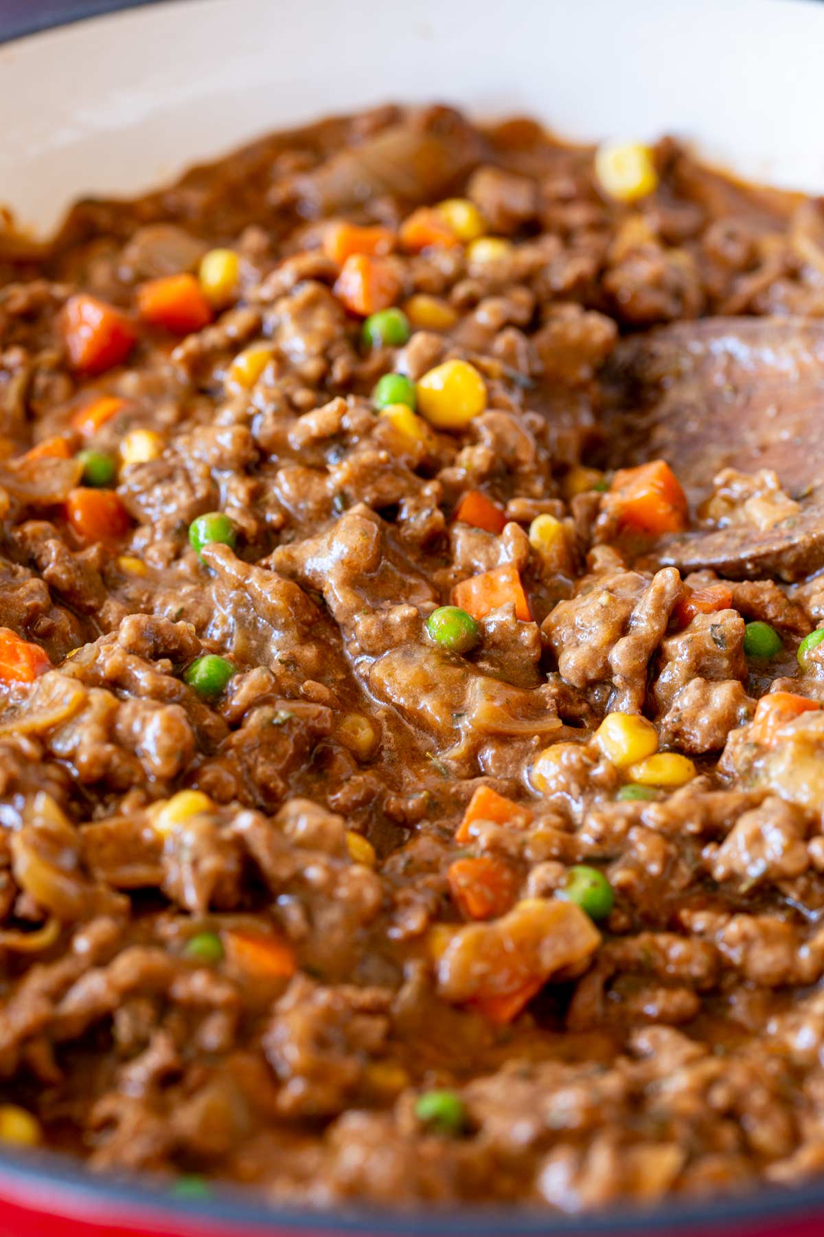 A close-up of ground beef and vegetables being served, revealing the hearty texture and vibrant colors of the dish.