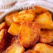 Pin Image: Close up of a bowl of roasted potatoes in a rustic dish with text overlaid