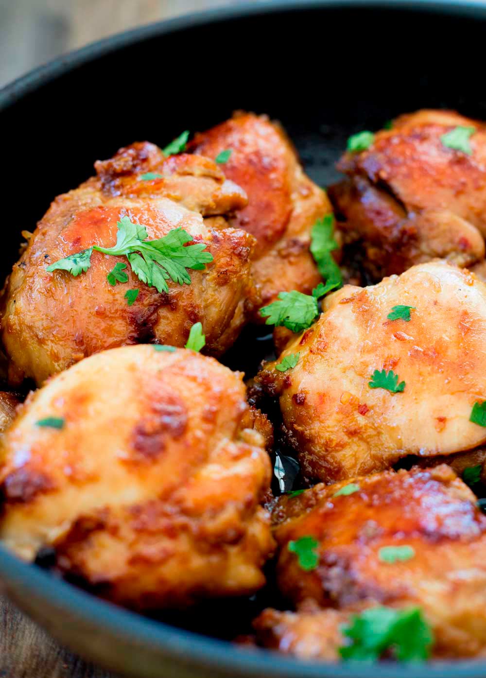 sticky chicken thighs in a black skillet
