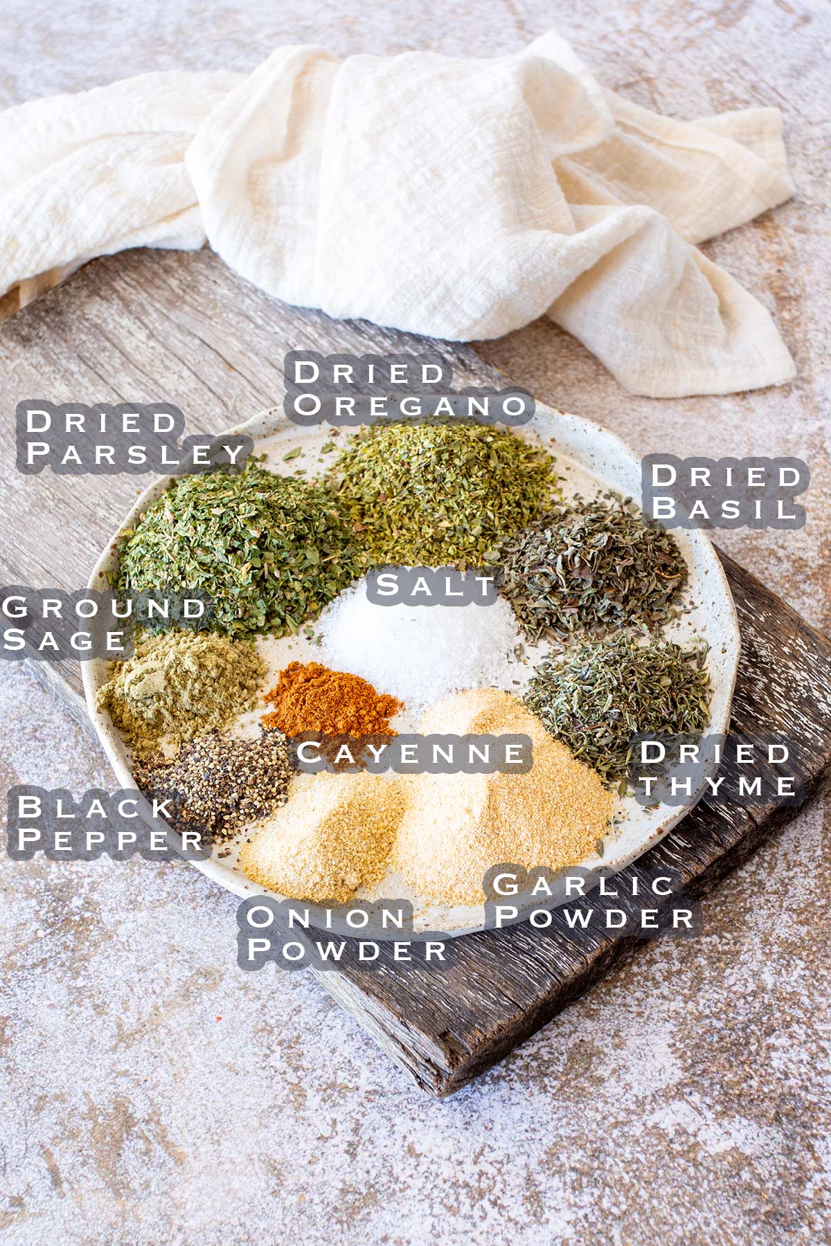 a plate with the ingredients for a garlic herb seasoning blend laid out and labeled.