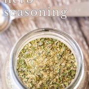 Pin Image: A glass jar of garlic and herb seasoning with text overlaid