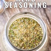 Pin Image: A glass jar of garlic and herb seasoning with text overlaid