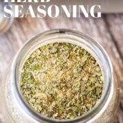 Pin Image: A glass jar of garlic and herb seasoning with text overlaid